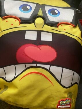 Sprayground Yellow SpongeBob Kids Backpack with Red Tongue and Blue Eyes